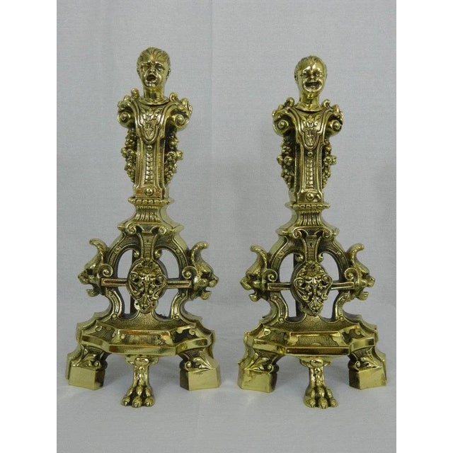 19th century pair of chenets or andirons with cherubs and lions motif ending on claw feet.