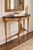 An exquisite Louis XVI-style demi-lune console table featuring elaborate giltwood ornamentation and a striking black...