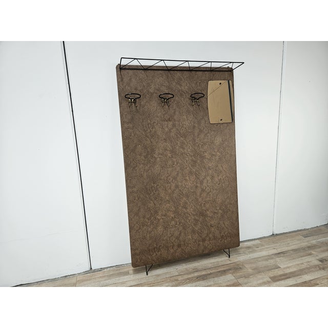 Vintage 1960s coat rack with a wooden frame covered in brown vinyl, very beautiful and decorative. It features an iron...