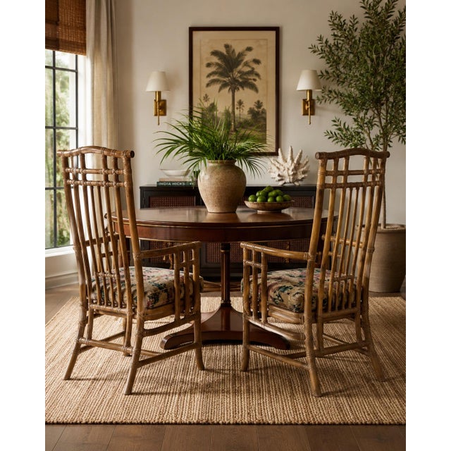 Bring timeless coastal charm to your home with this beautiful pair of vintage organic rattan arm dining chairs. Featuring...