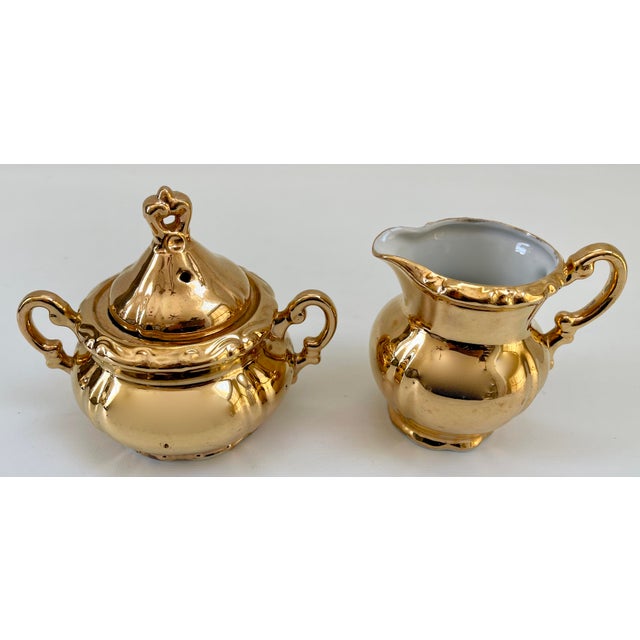 Sensational set of creamer and lidded sugar bowl decorated in a 24K gold plate over porcelain. Both in excellent vintage...