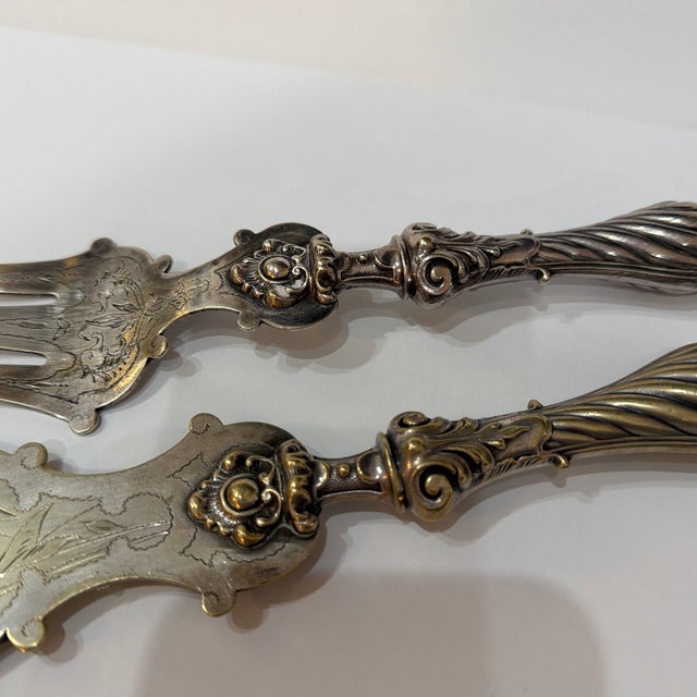 antique silver-plated fish serving set, featuring a large ornate fork and an engraved slice/knife with scrolled handles...
