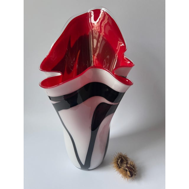 Large sculptural art glass vase featuring a dramatic handkerchief form with a flowing asymmetrical rim. The piece combines...
