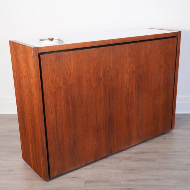 This is a rare and gorgeous mid-century modern walnut dry bar designed by Arthur Umanoff for Dillingham's "B Collection"....