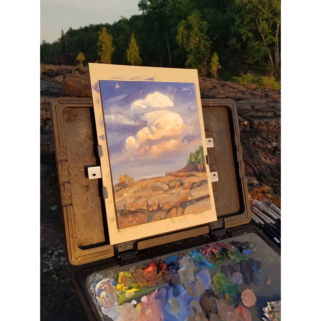 This oil painting on masonite captures a serene coastal landscape, showcasing gentle waves lapping against rocky shores...