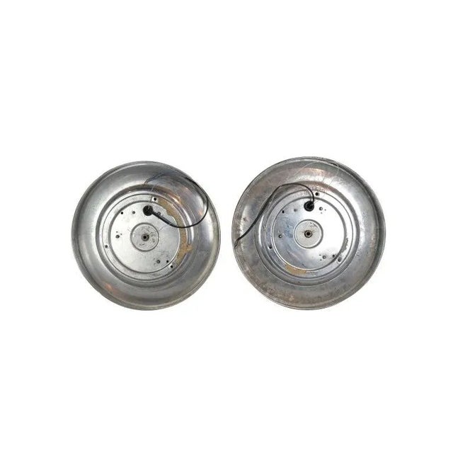 Pair of round disk French wall sconces or ceiling lights with a geometric patterned convex molded glass shade surrounded...