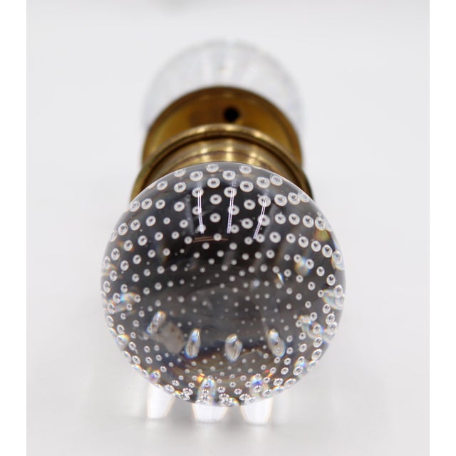 Ball shaped controlled bubble glass door knobs with a wide brass shank and rosettes. Good condition with appropriate wear...