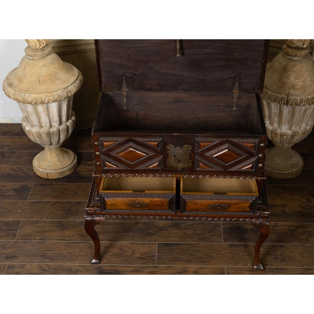 An Anglo-Indian geometric front mahogany coffer on base from the 19th century, with lift top, carved panels, two drawers,...