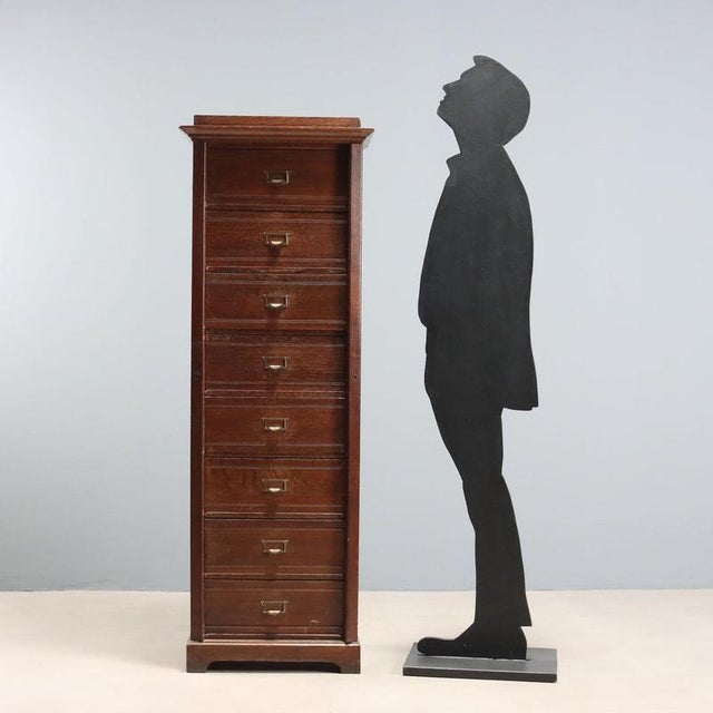 Oak chest of drawers. Eight hinged drawers with metal handles and label holders, and lockable side panels. Bracket legs....