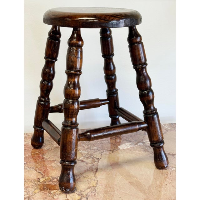 Antique stool featuring dark wood stain with turned wood legs. Seat 175"H. Alternative use as a plant stand. Natural age...