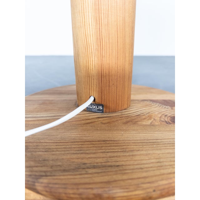This floor lamp, crafted by Luxus in pine wood, exemplifies Scandinavian design with its natural material and minimalist...