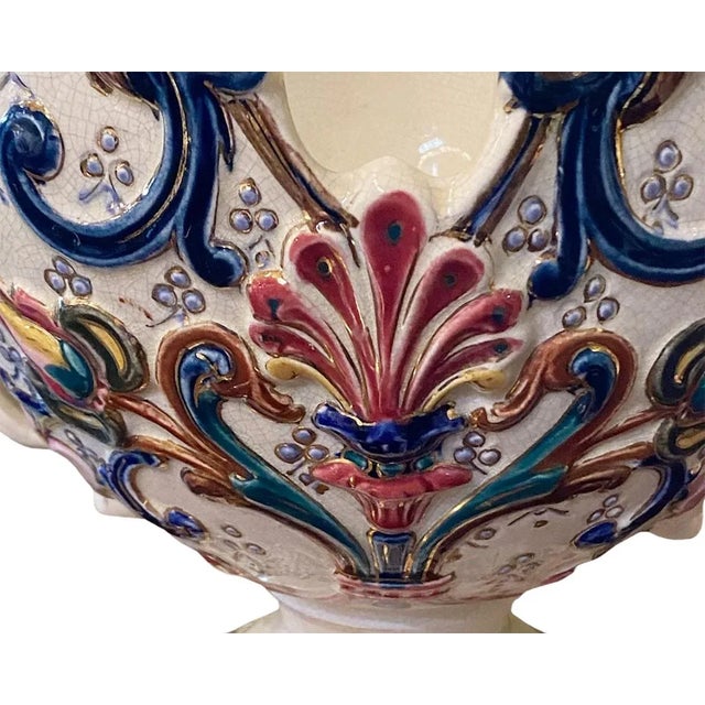 A white Barbotine majolica jardinière with deep rose, dark blue, green and yellow designs throughout. Signed on the...