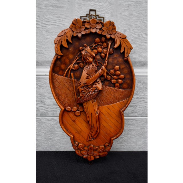 Vintage (1980's) Asian Wall Plaque. Made of Wood. Carved Wood. Brass Hanger. The Measurements: 7"W x 1"D x 12.5"H. Flat...