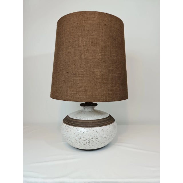 Large white glazed ceramic lamp. The part between the body of the lamp and the socket is in exotic wood Lampshade in brown...