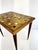 A striking mid-century modern side table featuring a geometric mosaic tile top in warm shades of caramel, amber, cream,...