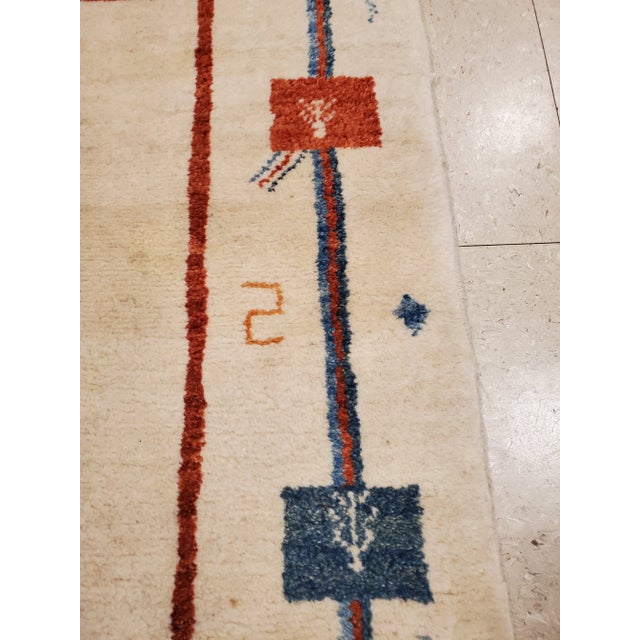 A whimsical vintage Persian Gabbeh rug with an natural creamy ivory/white background and a beautiful open design boarder....