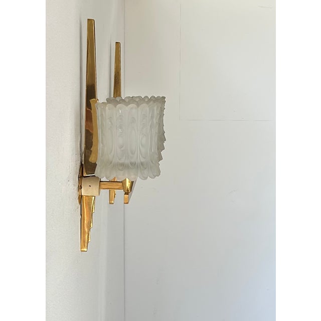 Pair of wall sconces in brass and sandblasted pressed glass, produced by Maison Arlus in France in the 1950s. Exquisite...