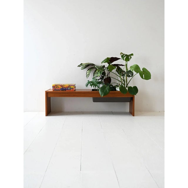 1960s teak coffee table with clean lines and a removable black plastic flower holder integrated into the frame....