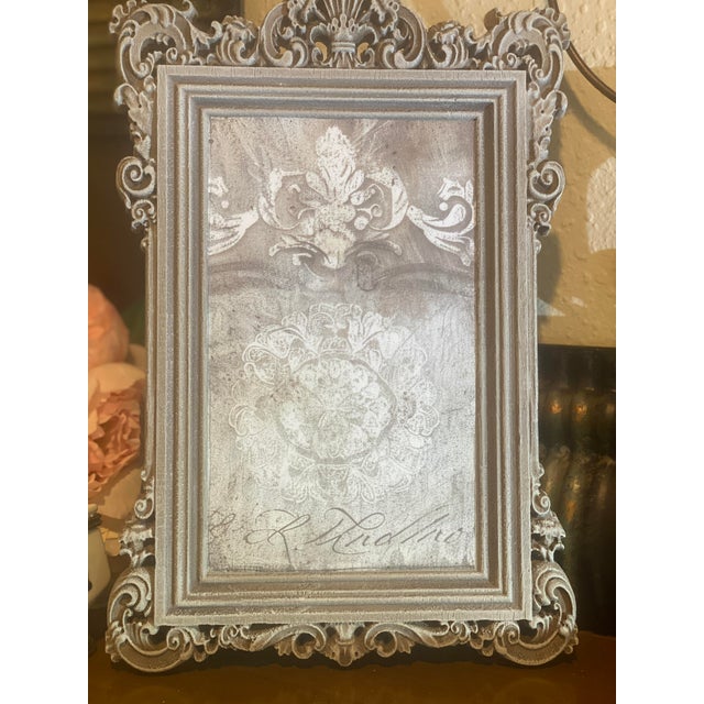 This one-of-a-kind decorative artwork features a custom decoupage paper framed in ornate French Country style. The...