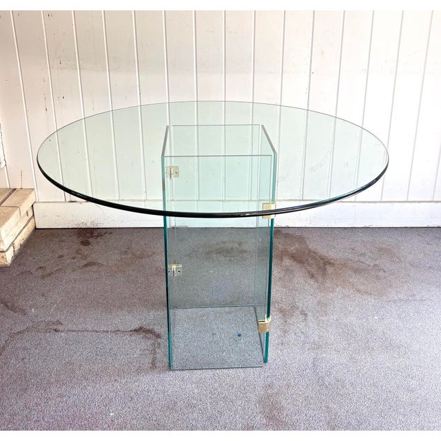 1970s Pace-style all glass round dining table w/ brass corner brackets. Can be configured in multiple ways with the 2-part...