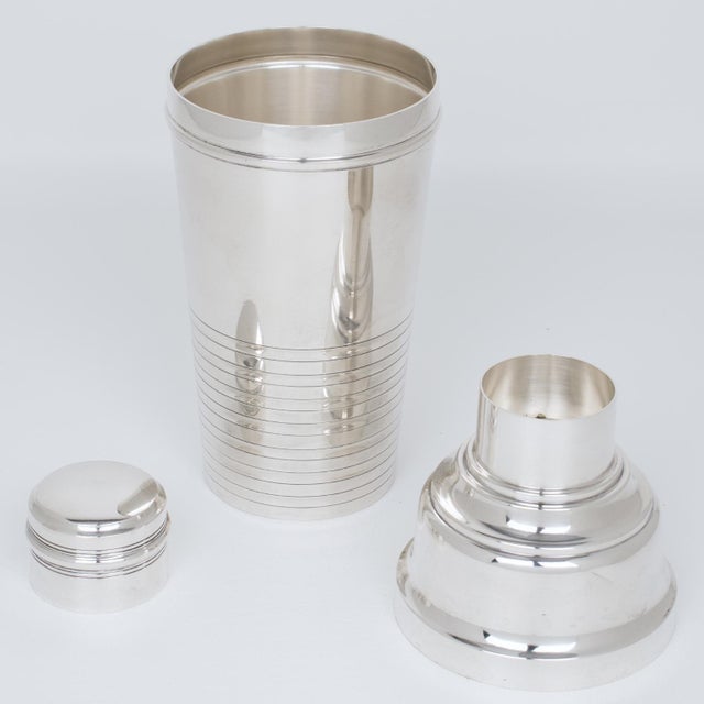 This elegant Art Deco silver plate cylindrical cocktail or Martini shaker was crafted by French silversmith Boulanger,...