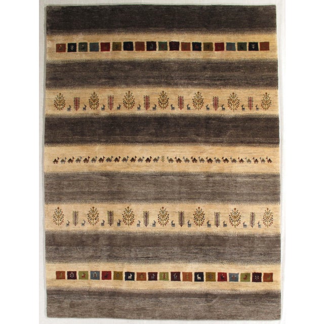 Vintage hand-knotted Persian Gabbeh rug with horizontal bands featuring geometric motifs, animals, and stylized trees....