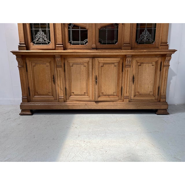 Attractive two-piece solid oak bookcase. four doors in the lower section with molded frames and paneling. upper section...