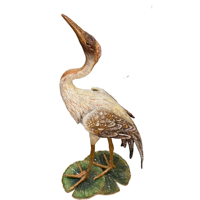 Jay Strongwater signed crane statue standing atop a lily pad base, hand-enameled with intricate feather texture and...