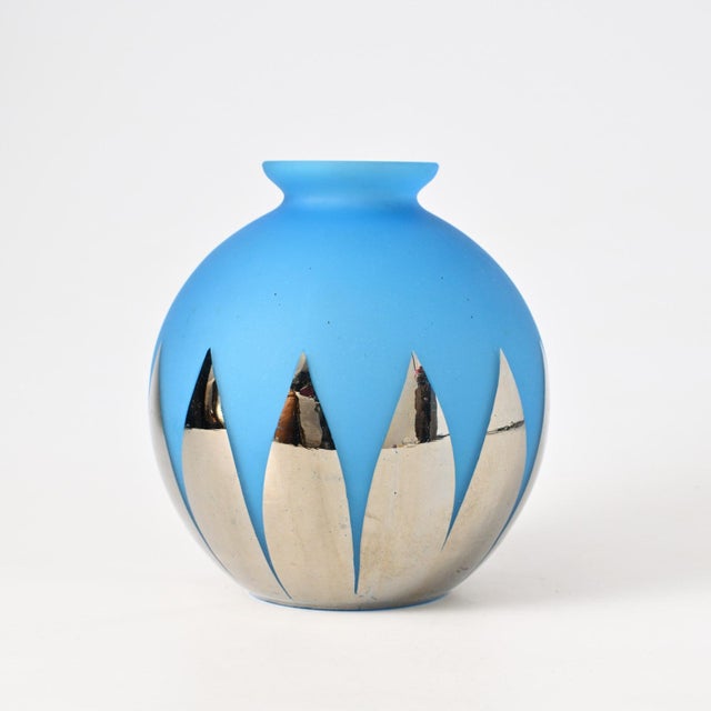 Spherical vase made of blue glass with a matte finish. Decorated with elongated, pointed silver mirror-like motifs.