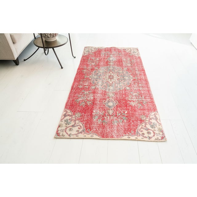 This is a vintage Turkish Oushak rug from the Mid 20th Century. The piece was hand-knotted.