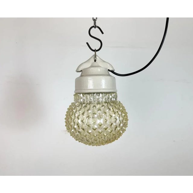 Vintage industrial light made in former Czechoslovakia during the 1970s. It features a white porcelain top and a glass...