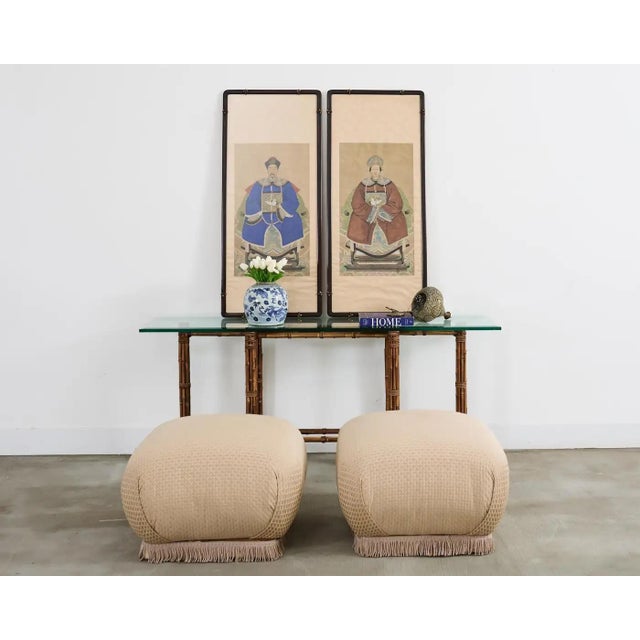 Stately pair of Chinese export ancestor portraits depicting a patriarch and matriarch of high ranking official status....