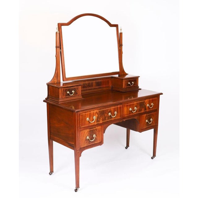 This is an elegant antique edwardian inlaid flame mahogany dressing table, circa 1900 in date. It features inlaid...