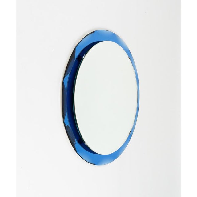 Midcentury amazing round wall mirror with blue glass frame and steel details in the style of Cristal Arte. Made in Italy...