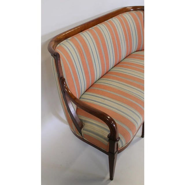 refined Swedish Neoclassical settee with strong Biedermeier influence, dating to the early 19th century, circa 1830. The...