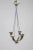 A solid, understated, shining silver chandelier with four upward facing, horn shaped arms. Recessed sockets have a clean...