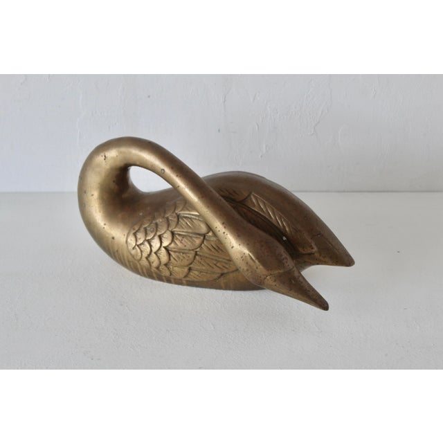 1970s Vintage brass swan sculpture, featuring intricate feather detailing on its wings and a graceful, curved neck. Eight...