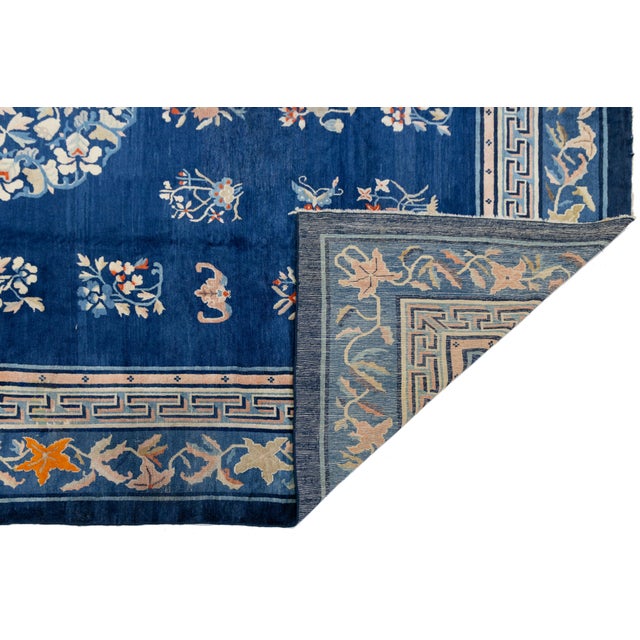 Antique Chinese wool rug, handknotted with a rich blue field and central floral medallion. Features symbolic motifs in a...