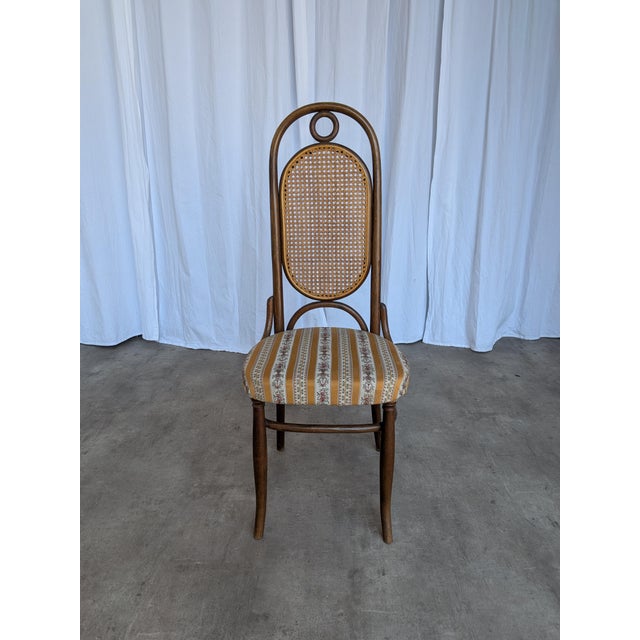 Wooden dining chair made in the Thonet style in Yugoslavia during the 1970s. The chair features a tall backrest with a...