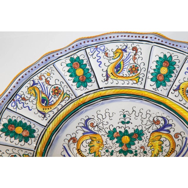 A large vintage Deruta Raffaellesco decorative wall plate with scalloped rim. Majolica hand-painted with magnificent...