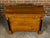 A French Empire fruitwood four-drawer commode from the early 19th century with ebonized columns, gilt Corinthian capitals...