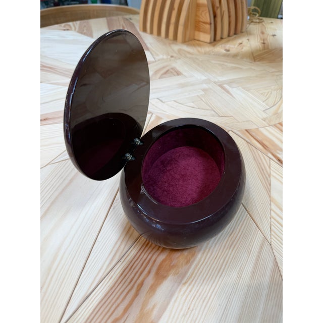 Vintage Italian oval vanity or jewelry box featuring a sculptural dark burgundy lacquered body and a smoked mirrored lid....