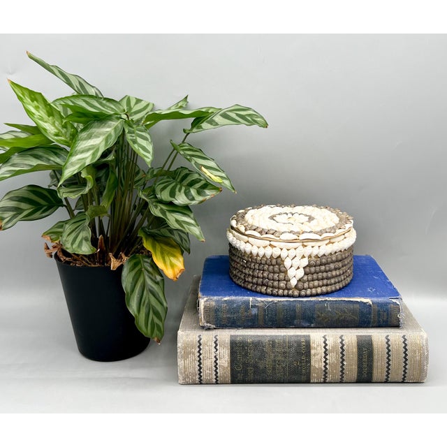 Charming vintage round trinket box richly decorated with an intricate mosaic of natural seashells arranged in concentric...