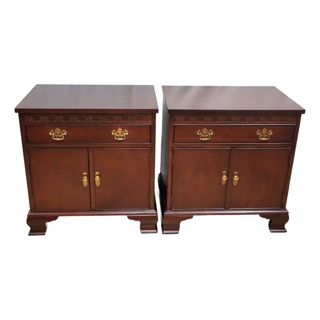 A matched pair of 1980s Baker Furniture Chippendale-style mahogany nightstands or bedside cabinets, crafted in the United...