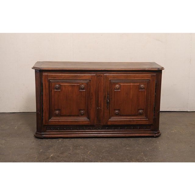 An Italian walnut credenza console from the early 19th century. This antique cabinet from Italy, a handsome and restrained...