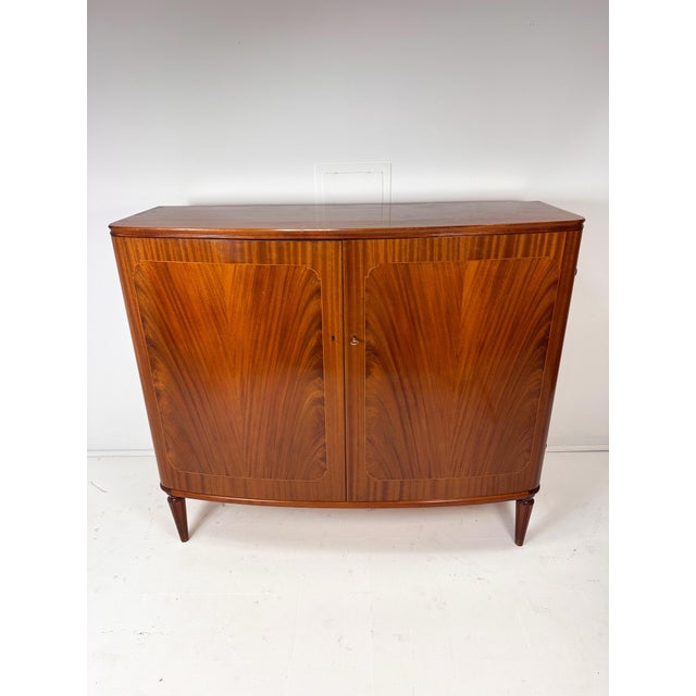 1930's Swedish Cabinet With Decorative Inlay. 2 doors conceal interior shelves and 3 small drawers. Carved wood legs,...