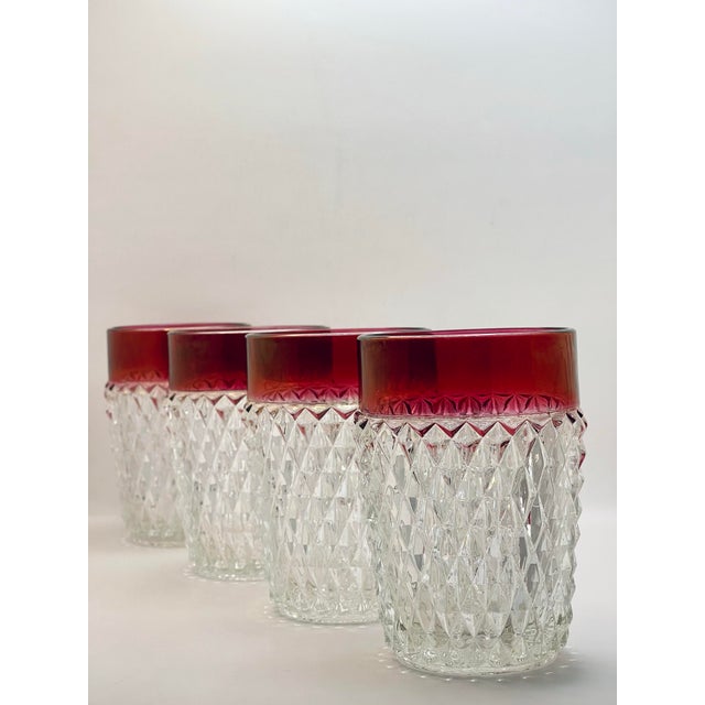 A set of four vintage diamond pattern juice/lowball glasses with a ruby red border. This piece is most likely made by the...