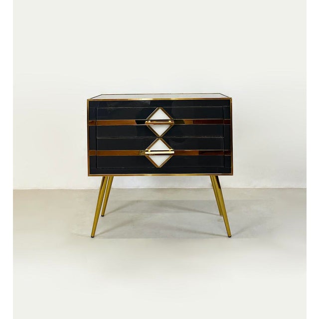 Particular Vintage 1970 bedside table entirely in dark grey coloured glass with brass details. Characterised by two front...