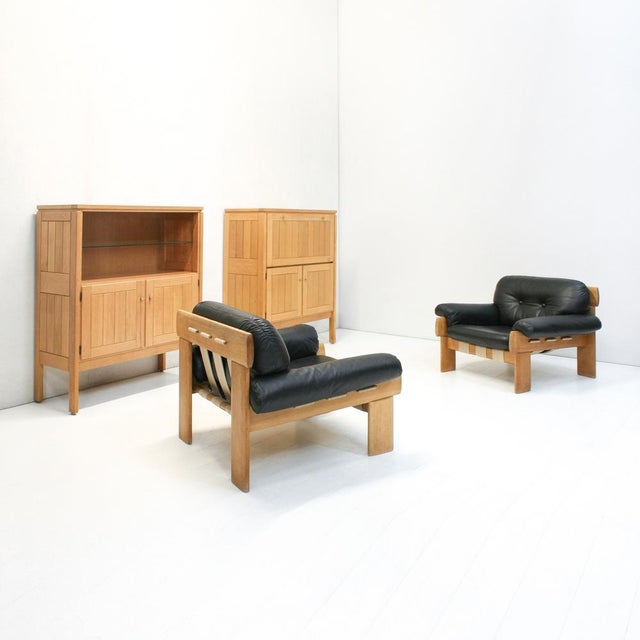 A set of two Country oak cabinets designed by Jos De Mey for Van Den Berghe Pauvers. The display cabinet has an open space...