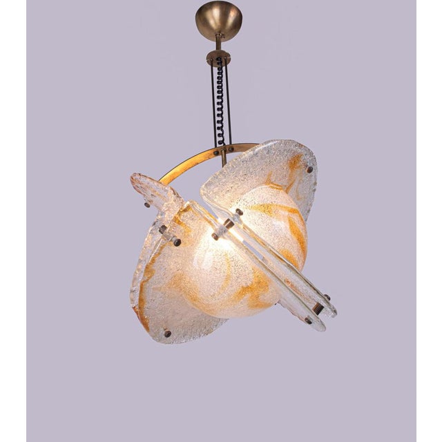 Beautiful pendant light with three sculptural clear and orange/amber thick Murano glass elements on a brass frame. Gem...